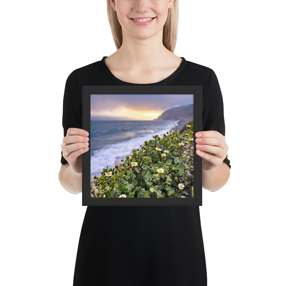 Framed coastal sunset photo poster with black frame, ocean waves, and wildflower blooms